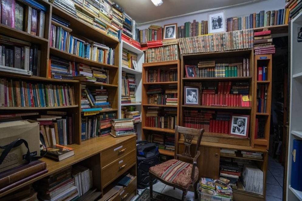 Sala con escritorio de madera y retratos de escritores