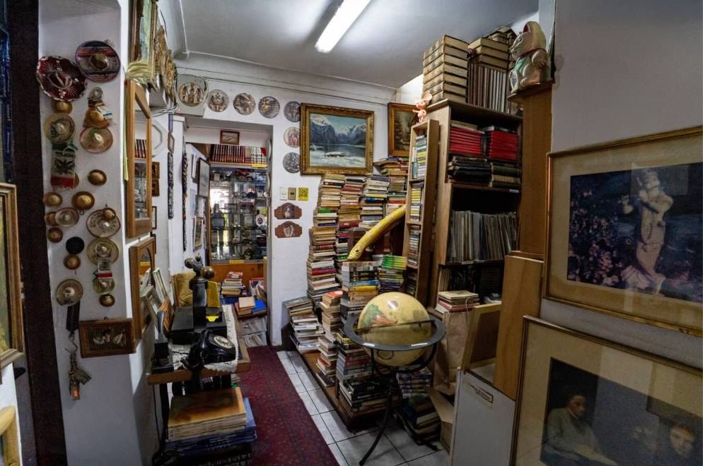 Sala con globo terráqueo, teléfono antiguo y libros apilados